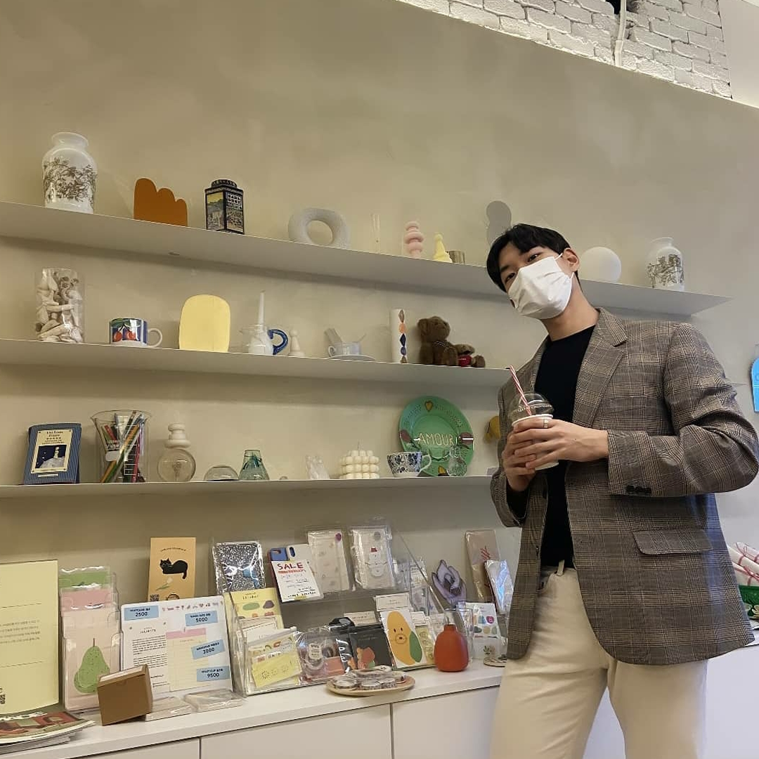 man wearing a blazer standing infront of a shelf with goods at Cafe Skön Hongdae