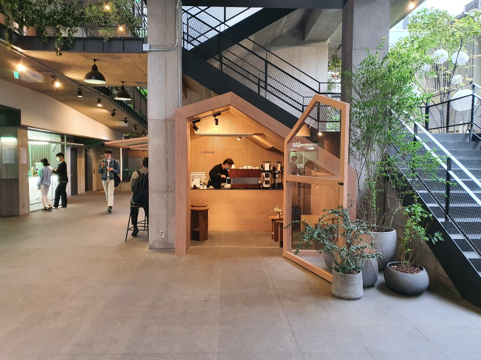 Interior dalam Garogolmok dengan bar kopi terbuat dari kayu dengan tanaman hias di sekitar.