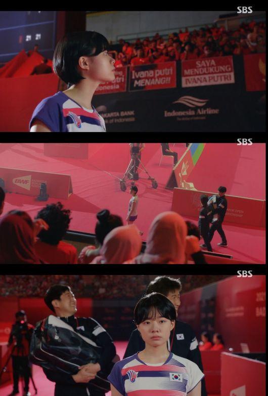 SBSのドラマ「ラケット少年団」で選手が試合前にコーチと話しているシーン。観客席からはインドネシアの観客が応援のために集まり、バックグラウンドには大会関連の横断幕が掲げられている。