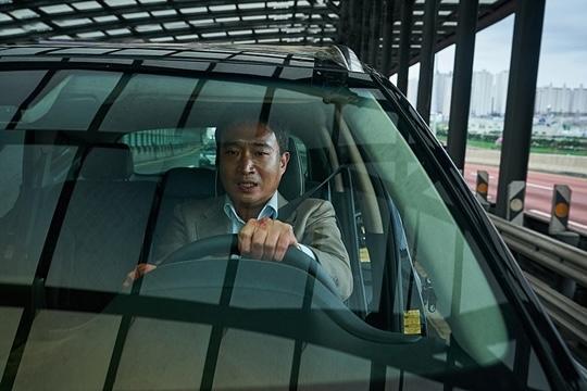 車を運転する男性、韓国映画『発信制限』の一場面。