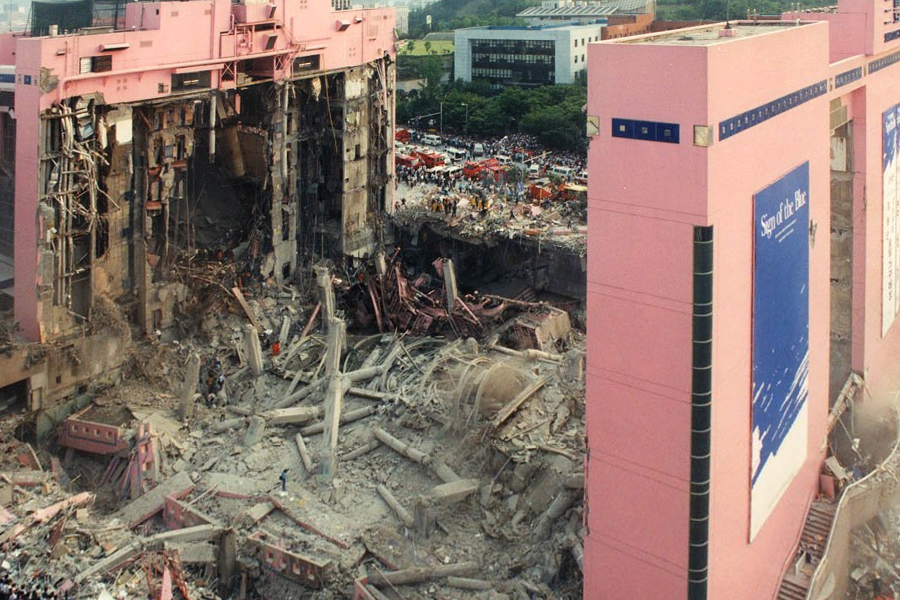 顯示三豐百貨坍塌後的建築殘骸，粉紅色牆體崩裂。