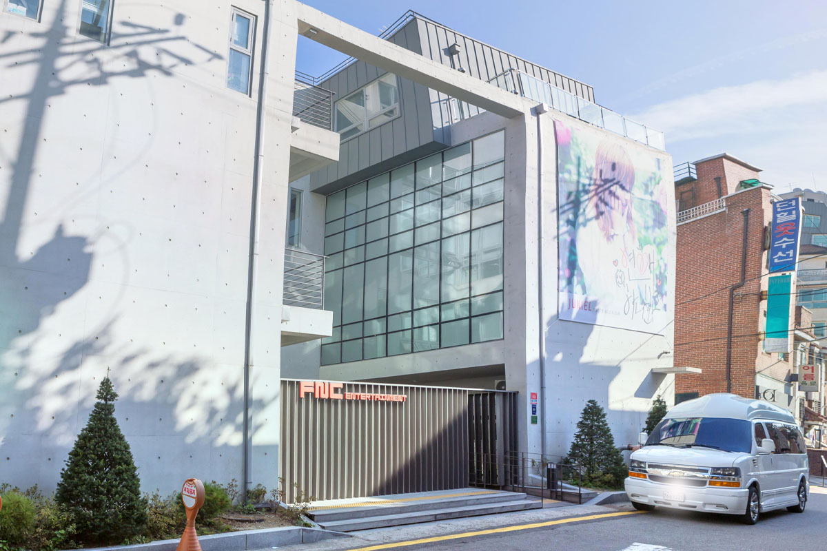 韓國FNC娛樂公司辦公大樓，白色混凝土建築，現代化設計與大窗户。