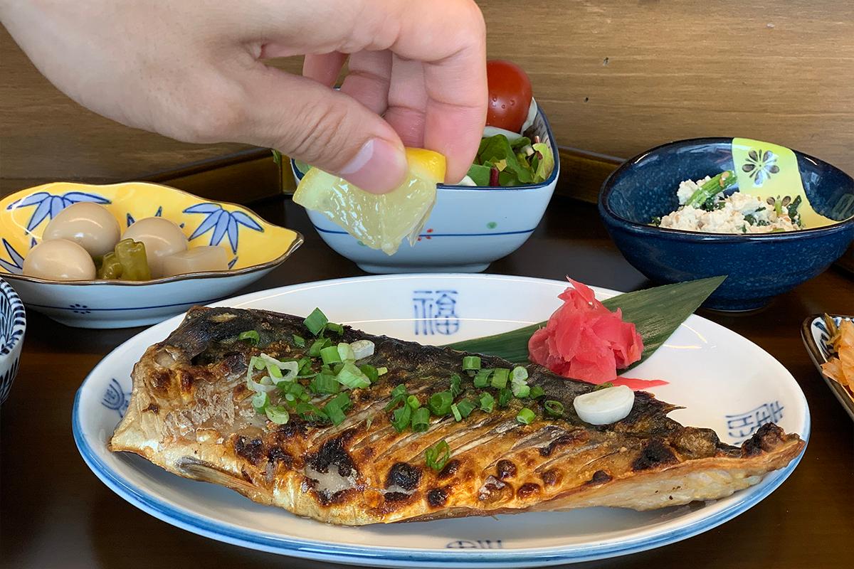 Customer squeezing some lemon juice on top of grilled fish