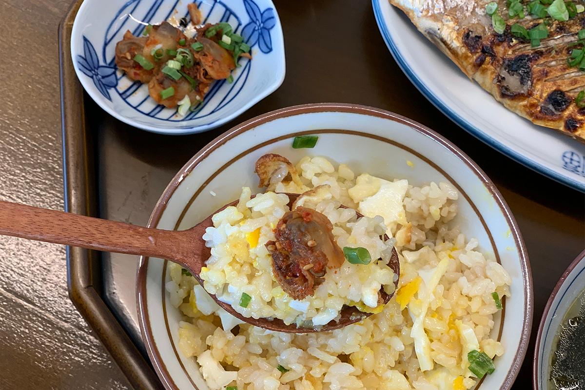 Spoonful of rice with some pickled side dish on top
