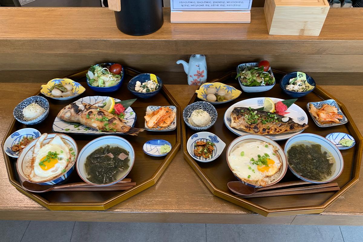Two grilled fish orders on large trays on table in restaurant