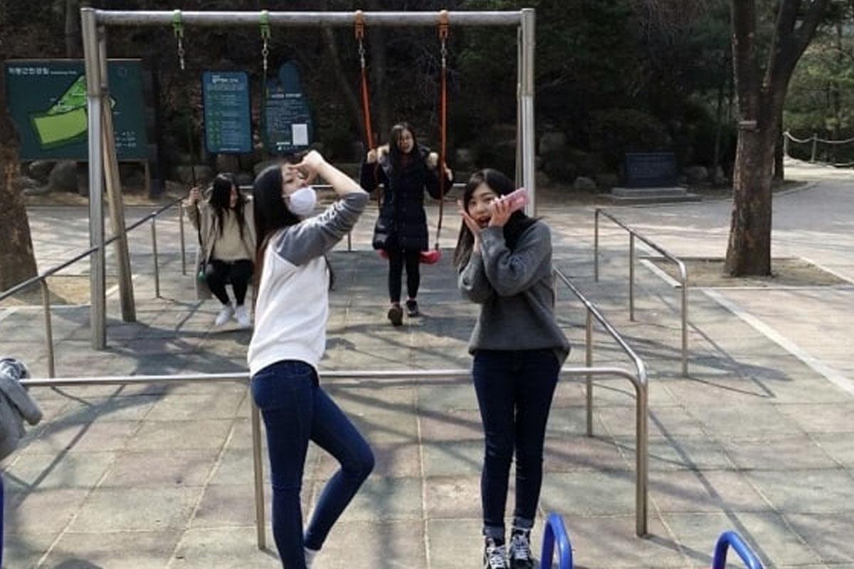 สมาชิกวง APRIL หน้าชิงช้าสวรรค์ในสวนสาธารณะแสดงถึงช่วงเวลาแห่งความสุข