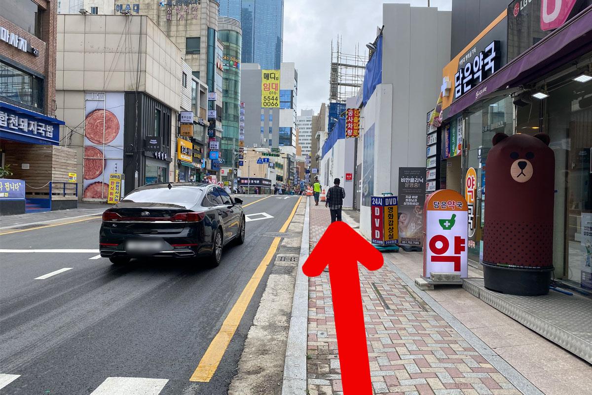 Un hombre usando mascarilla en el cruce de un calle en Busan.