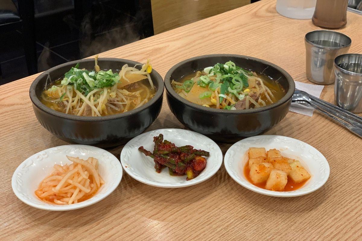 Các món gukbap nóng hổi và món ăn kèm tại nhà hàng Haeundae Wonjo Halmae Gukbap ở Busan, Hàn Quốc.