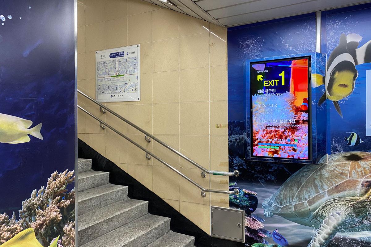 Escalera de la salida 1 en la Estación de Haeundae decorada con peceras.