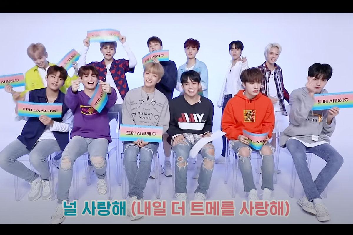 แฟนชาวเกาหลีกำลังถือป้ายไฟที่แสดงข้อความสนับสนุนวงไอดอลในระหว่างการสัมภาษณ์