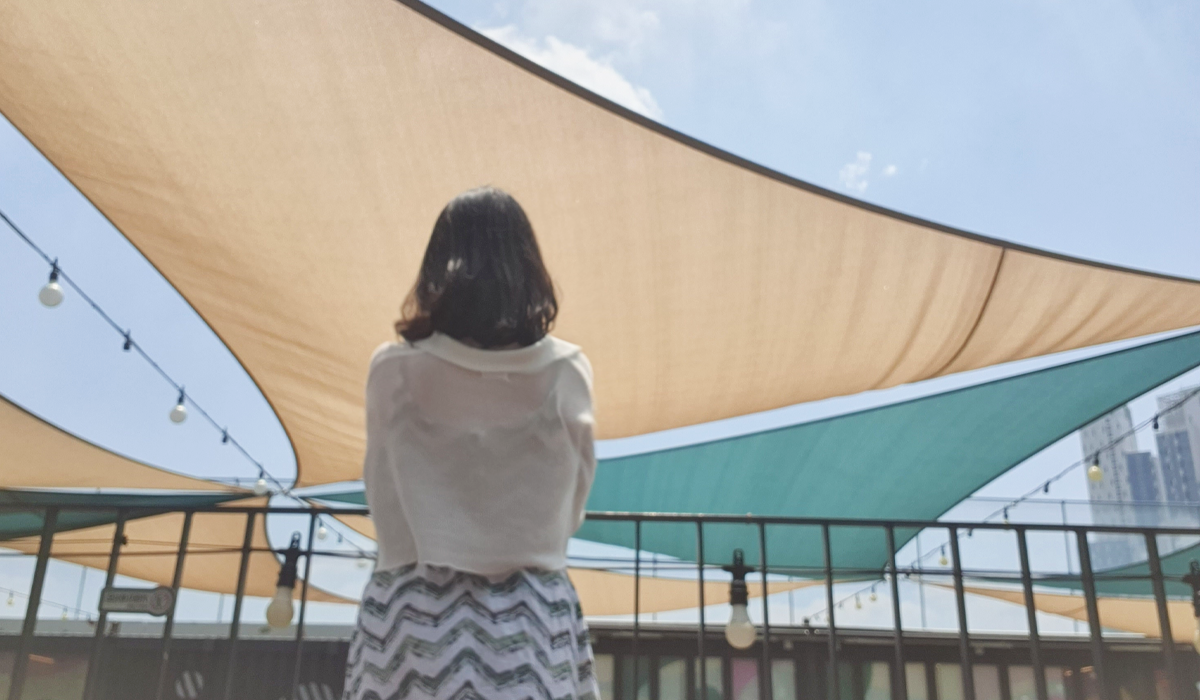 Visitor standing in front of covered seating area of shopping center in Seoul