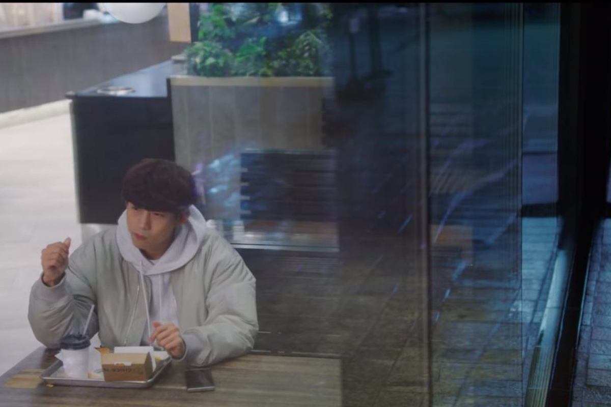Inquadratura interna del ristorante Shake Shack, con un grande schermo e clienti seduti.