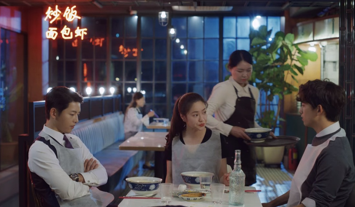 Scena esterna del ristorante Gugudang ambientata di notte, con insegne luminose.