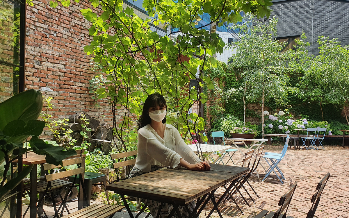 Customer sitting in outdoor garden area of cafe