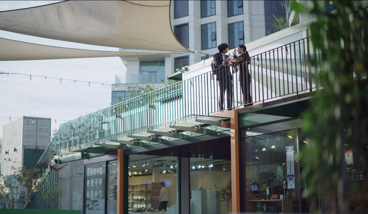 Scena a Understand Avenue con vista del mercato al piano inferiore e luci appese sopra.