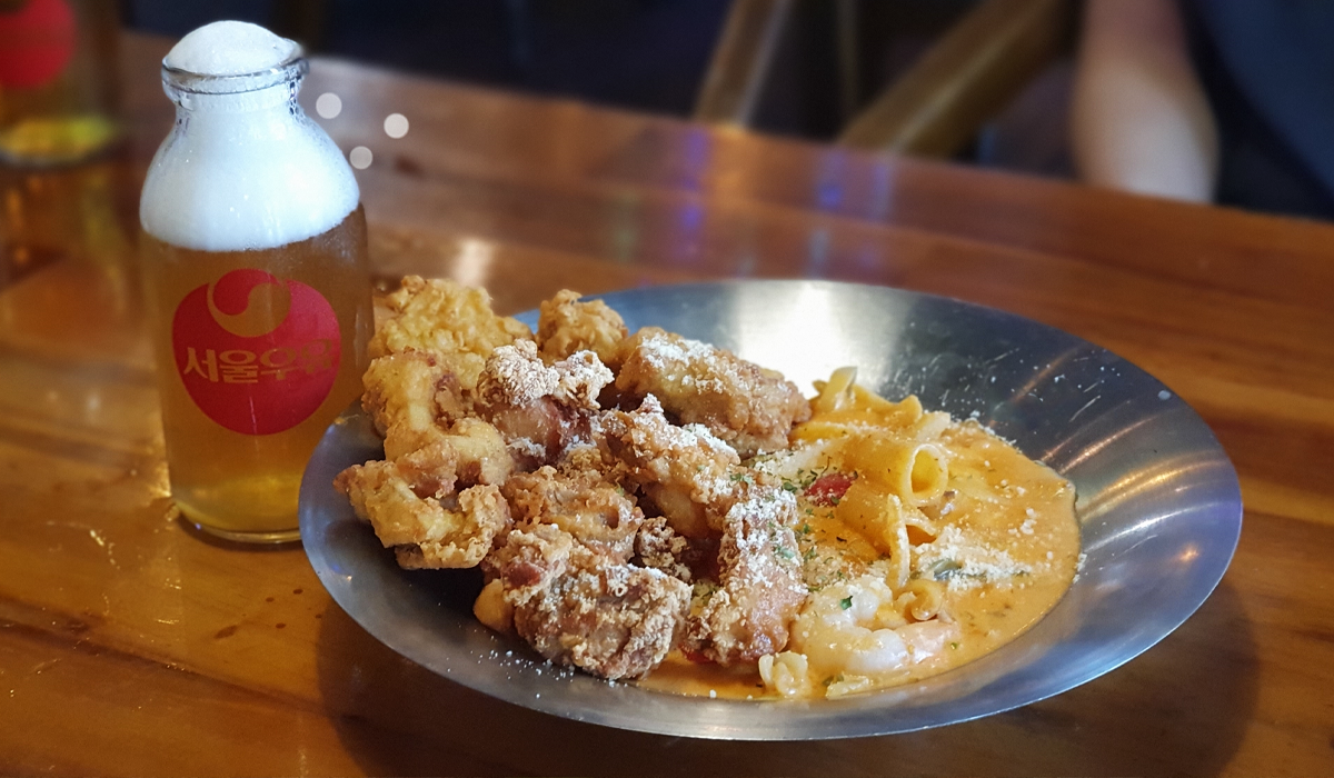 Chicken and pasta dish with bottle of beer