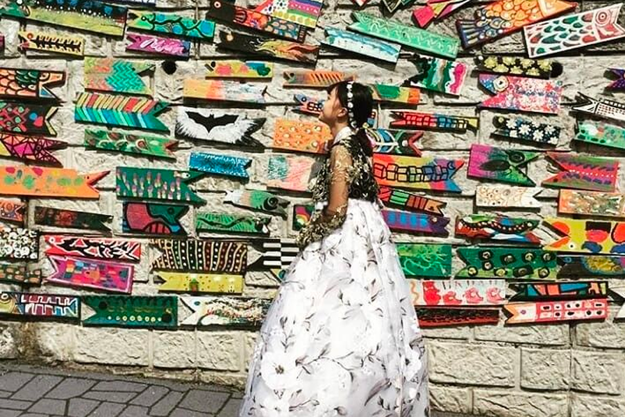 Colorful arrows artwork on a wall at Gamcheon Culture Village, showcasing traditional Korean hanbok with vibrant patterns.