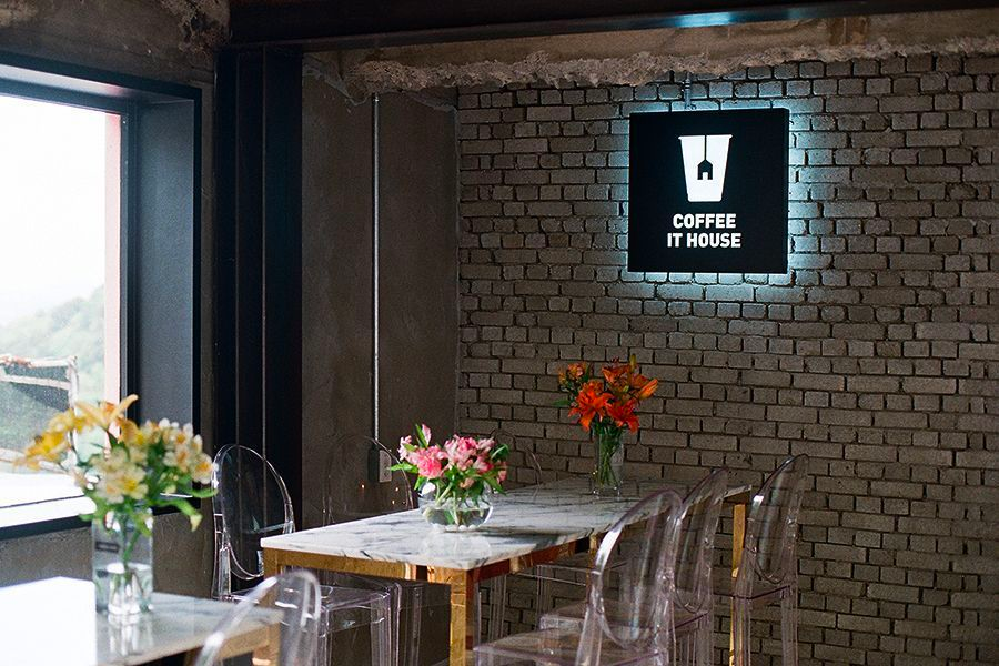 Interior of Coffee It House in Gamcheon Culture Village, featuring modern decor with floral arrangements, perfect for a relaxing coffee break.