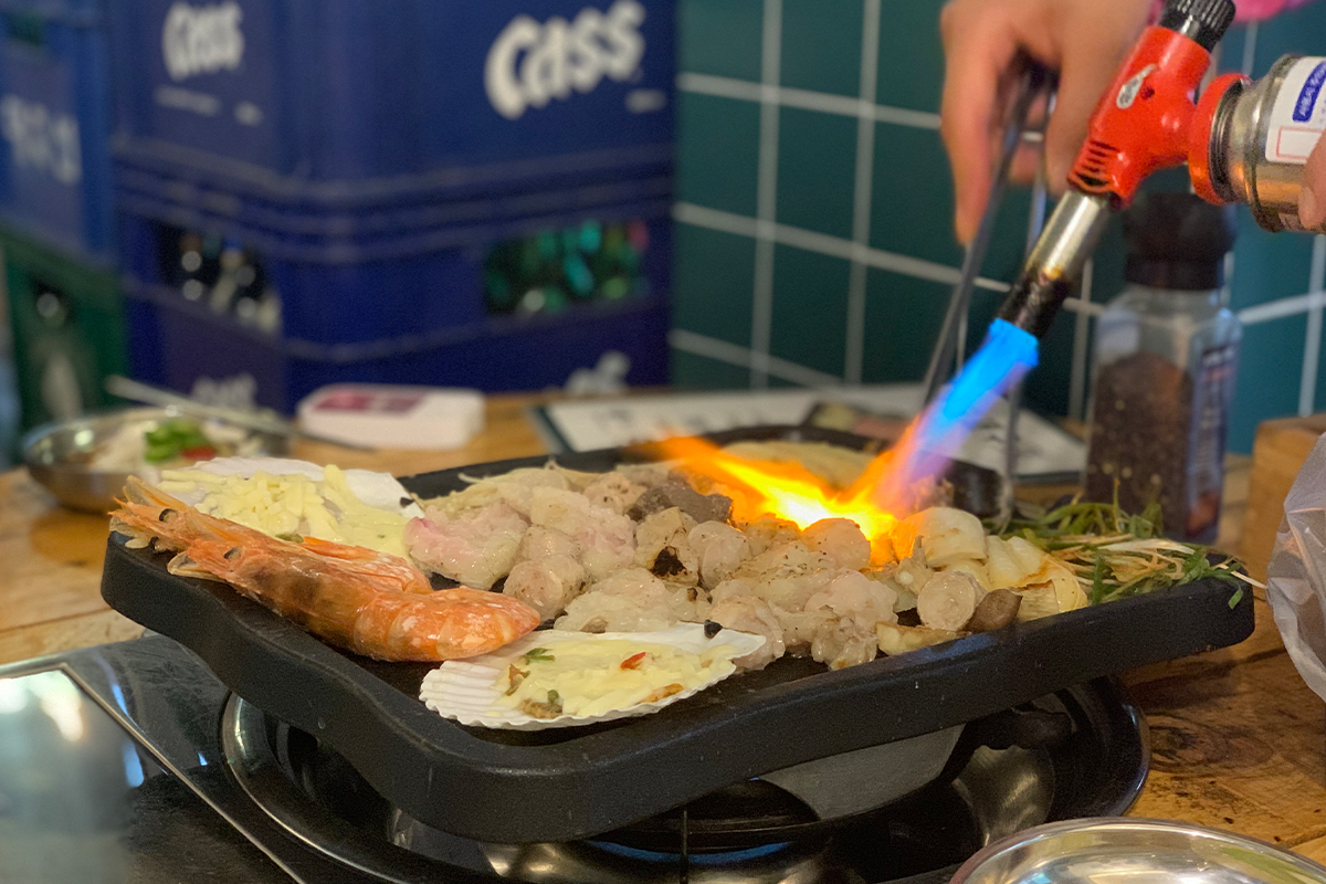 Blowtorch being used to cook food on grill