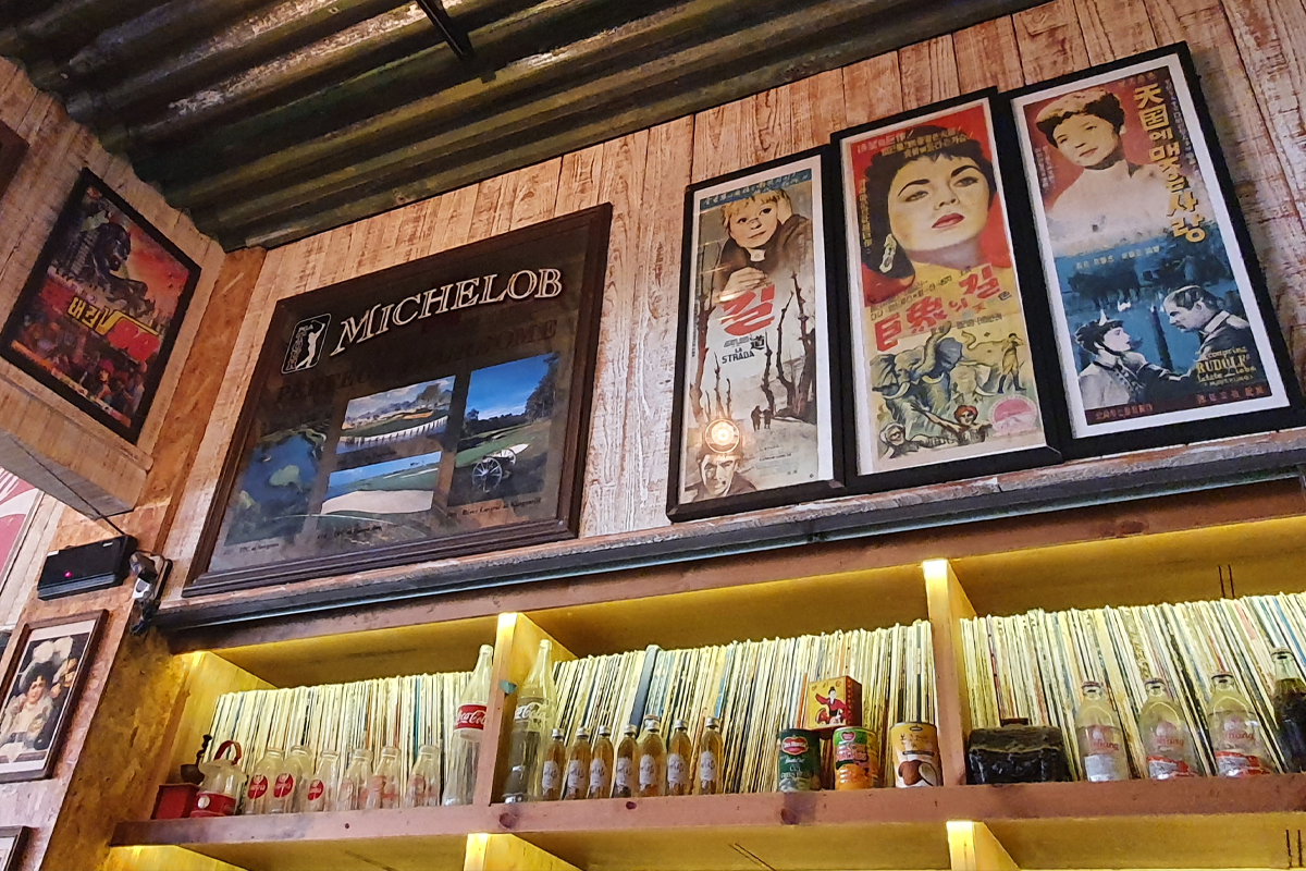 Display of movie posters, vinyl records, and glass bottles