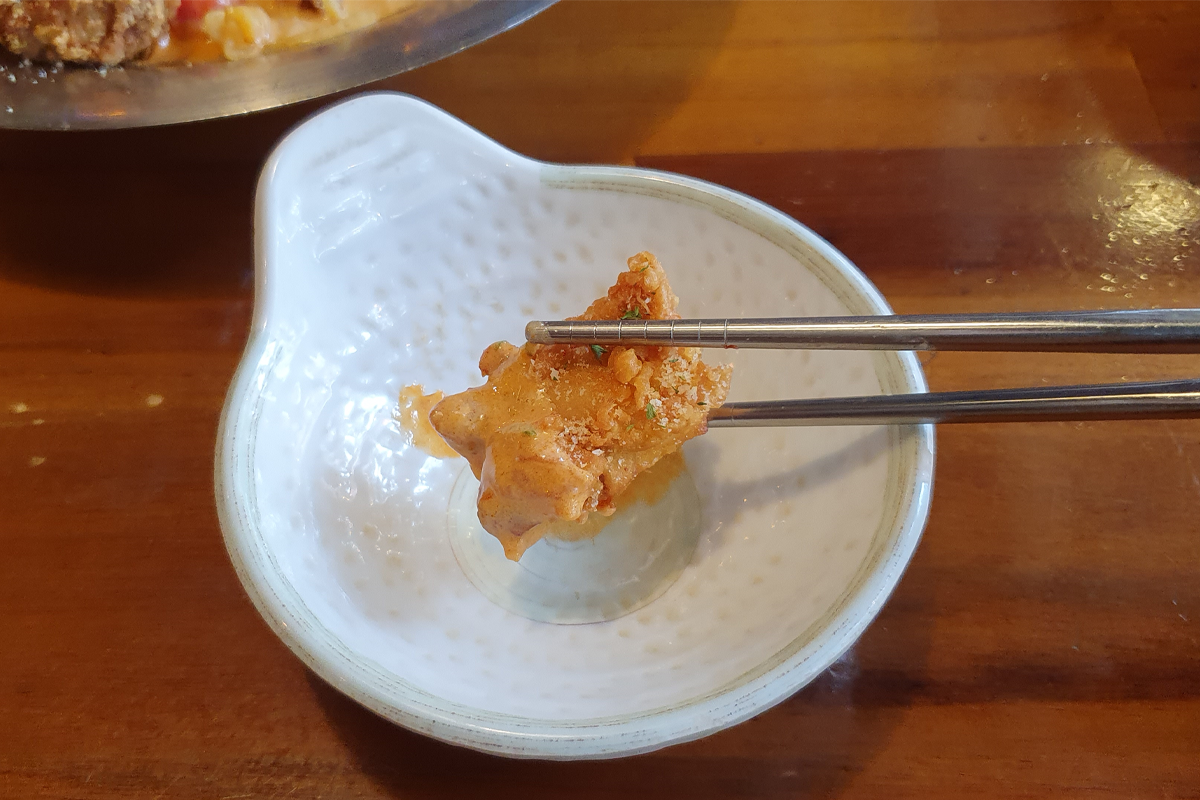 Close-up shot of piece of fried chicken with rose sauce