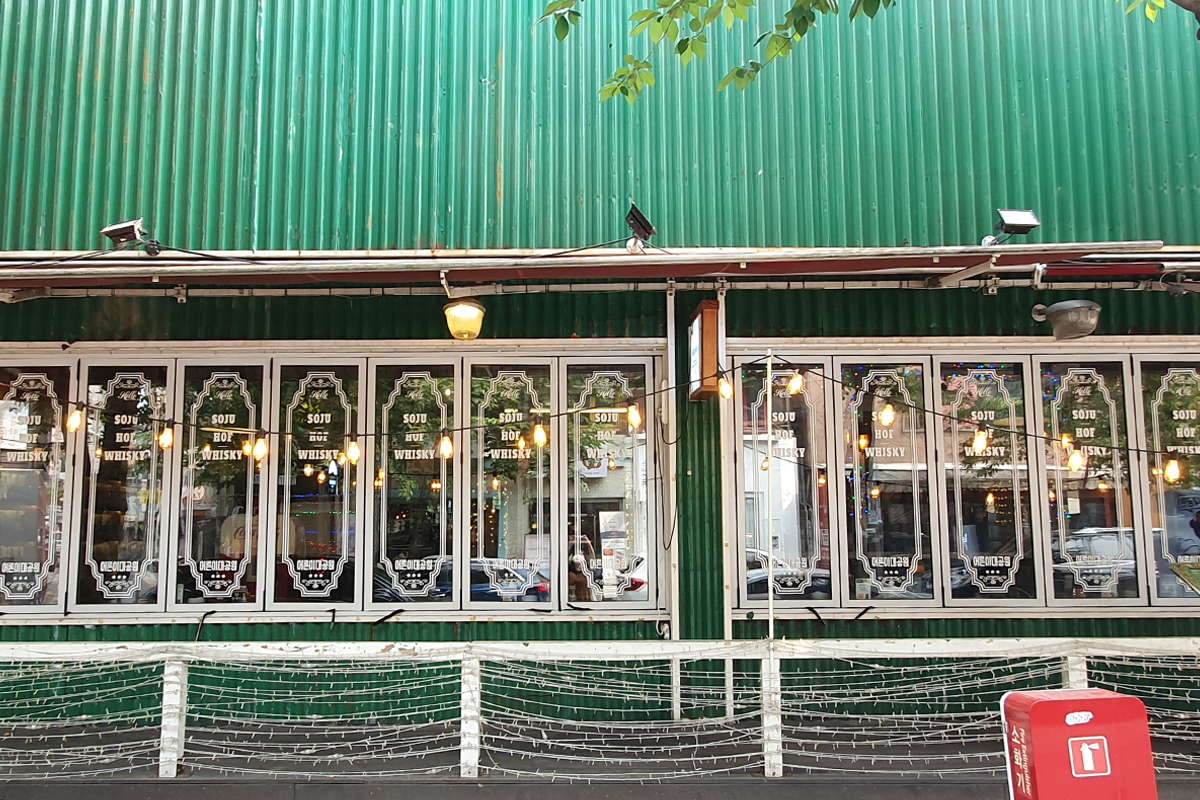 Exterior of Adult Grand Park bar featuring patio lights