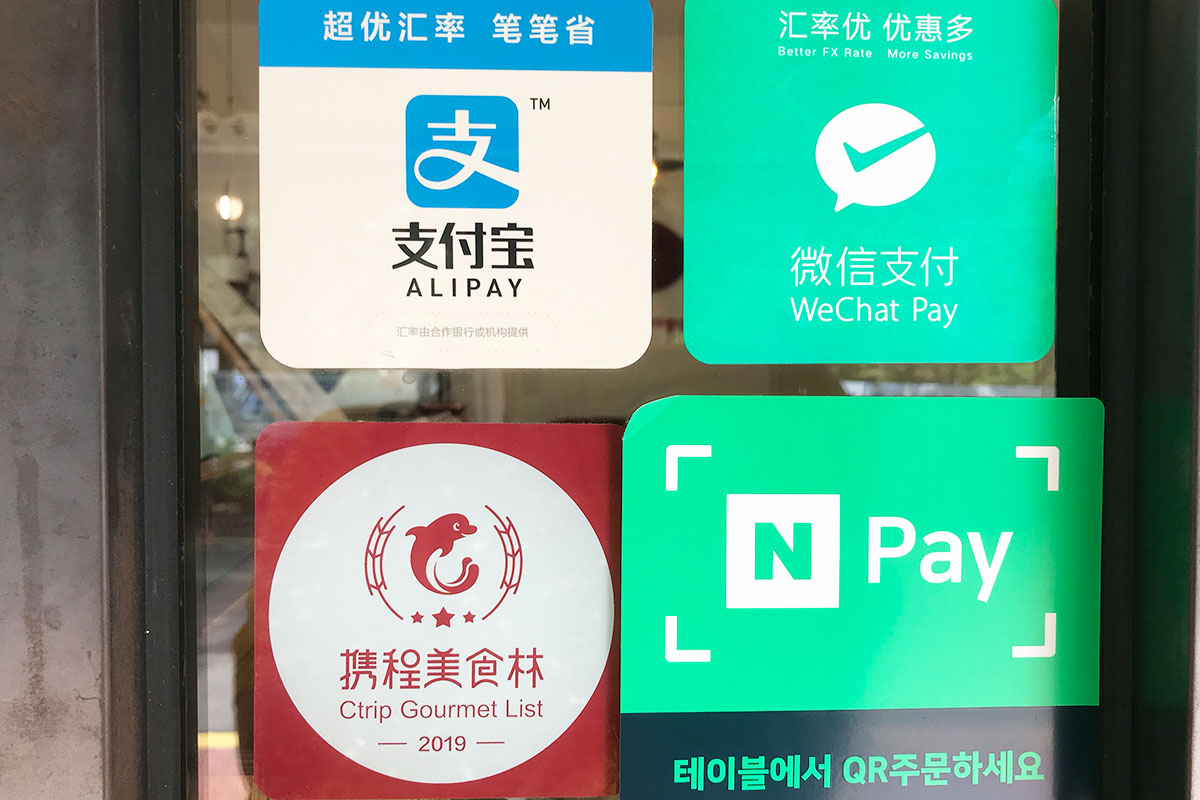 Different signs on door of various ways customers can pay