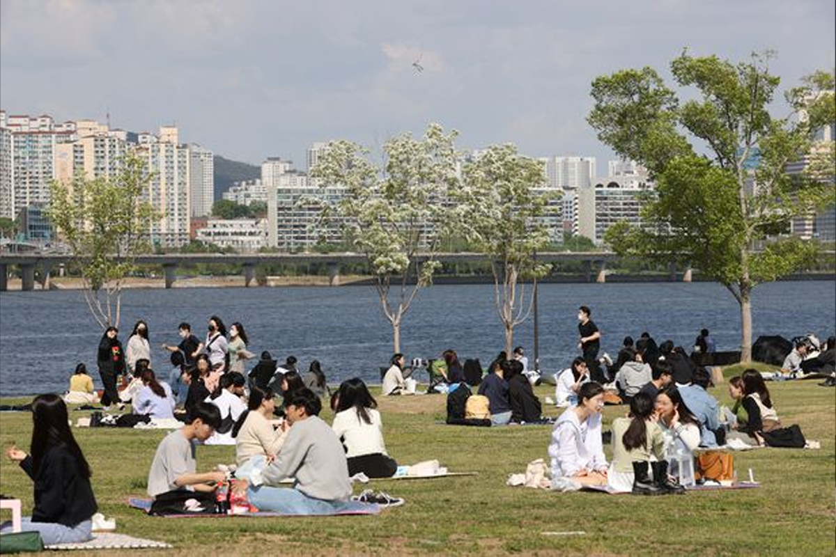 Koreans sitting on grass at the Han River