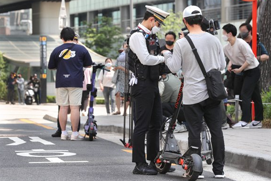 韓國路上的電動滑板車，展示韓國法律對電動滑板車使用者的罰則。