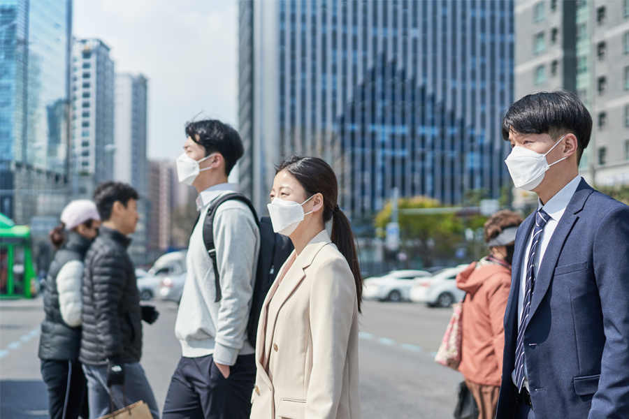 韓國城市中戴著口罩的行人，表示新冠肺炎時期的法律罰則與口罩必要性。