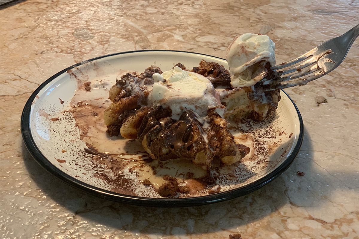 釜山現代桌子咖啡館內的水果沙拉和綠色果汁，搭配一旁的巧克力淋面和雪糕鬆餅，擺放在大理石桌上。