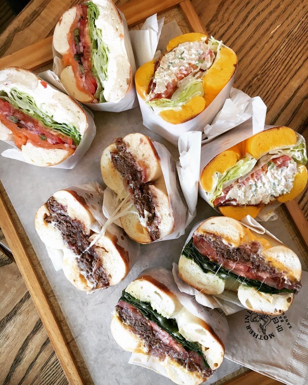 整齊排列的百吉餅三明治，上面放有新鮮蔬菜和美味肉類，適合午餐選擇