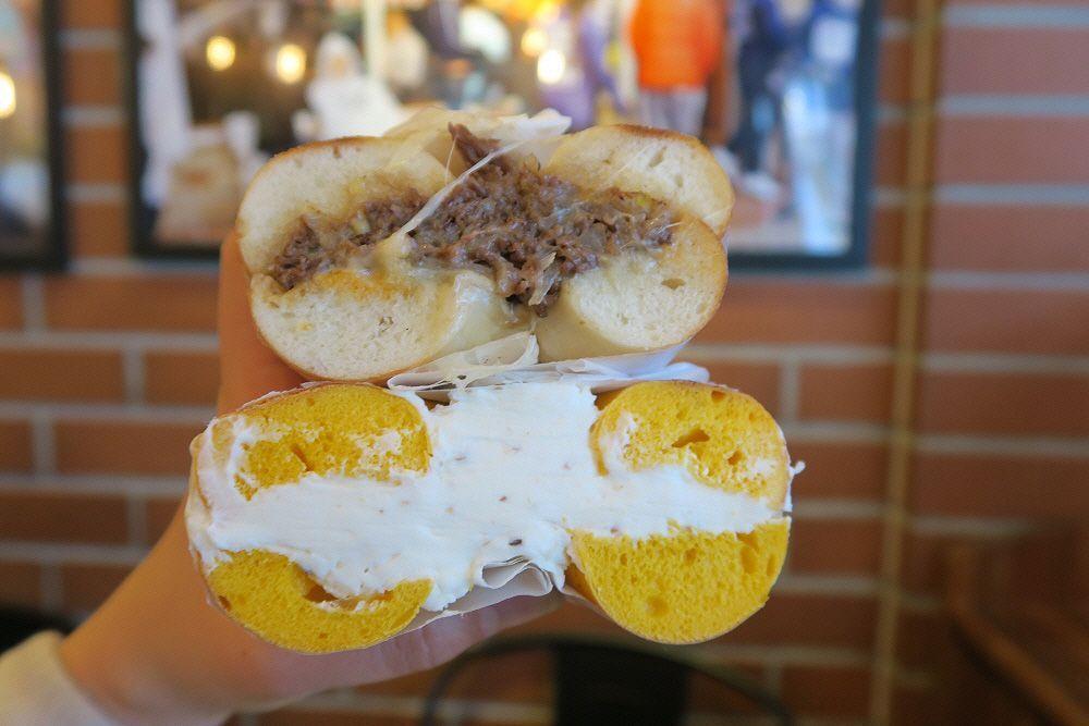 Mother in Law Beagle飯店招牌前展示的百吉餅，通過切開的橫截面顯示內餡