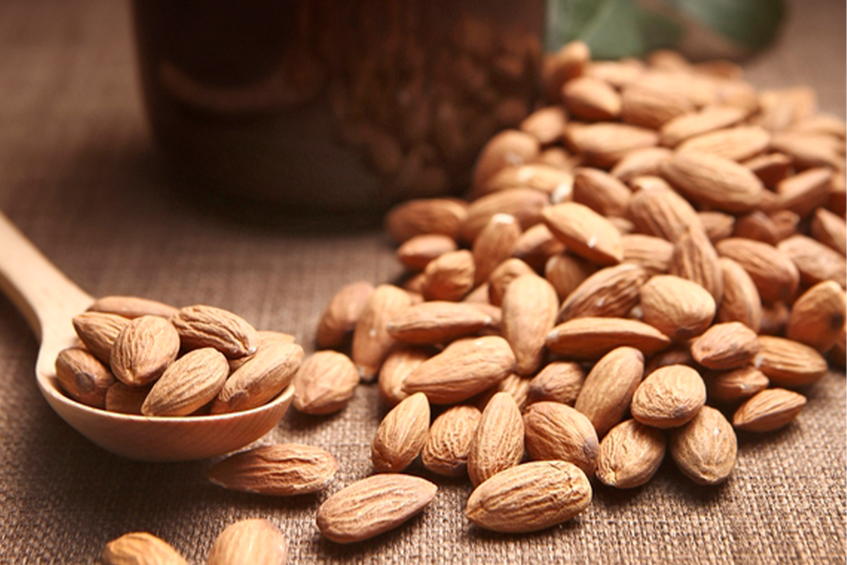 木匙裝著幾粒杏仁，擺喺木桌上，呢啲堅果可以幫助降低宿醉影響。