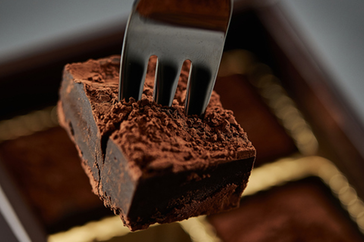 叉子插住一塊外層佈滿可可粉嘅朱古力，朱古力可以幫助延緩酒精吸收。