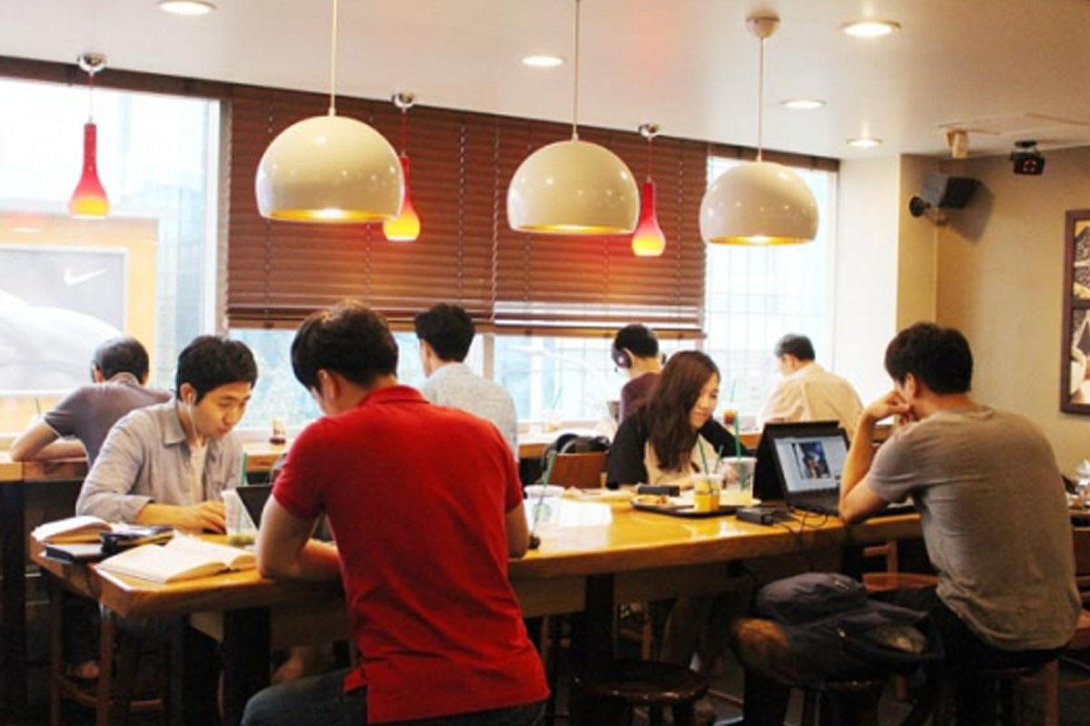 韓國咖啡店內人們使用筆電工作及學習的情景，顯示學習氣氛與No Study Zone議題