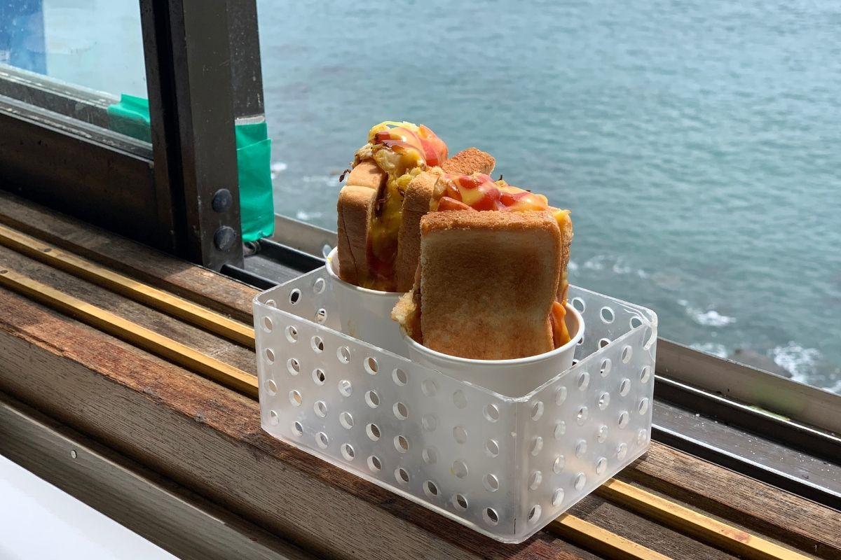 Toast in window with ocean backdrop at Huinnyeoul Jeombbang