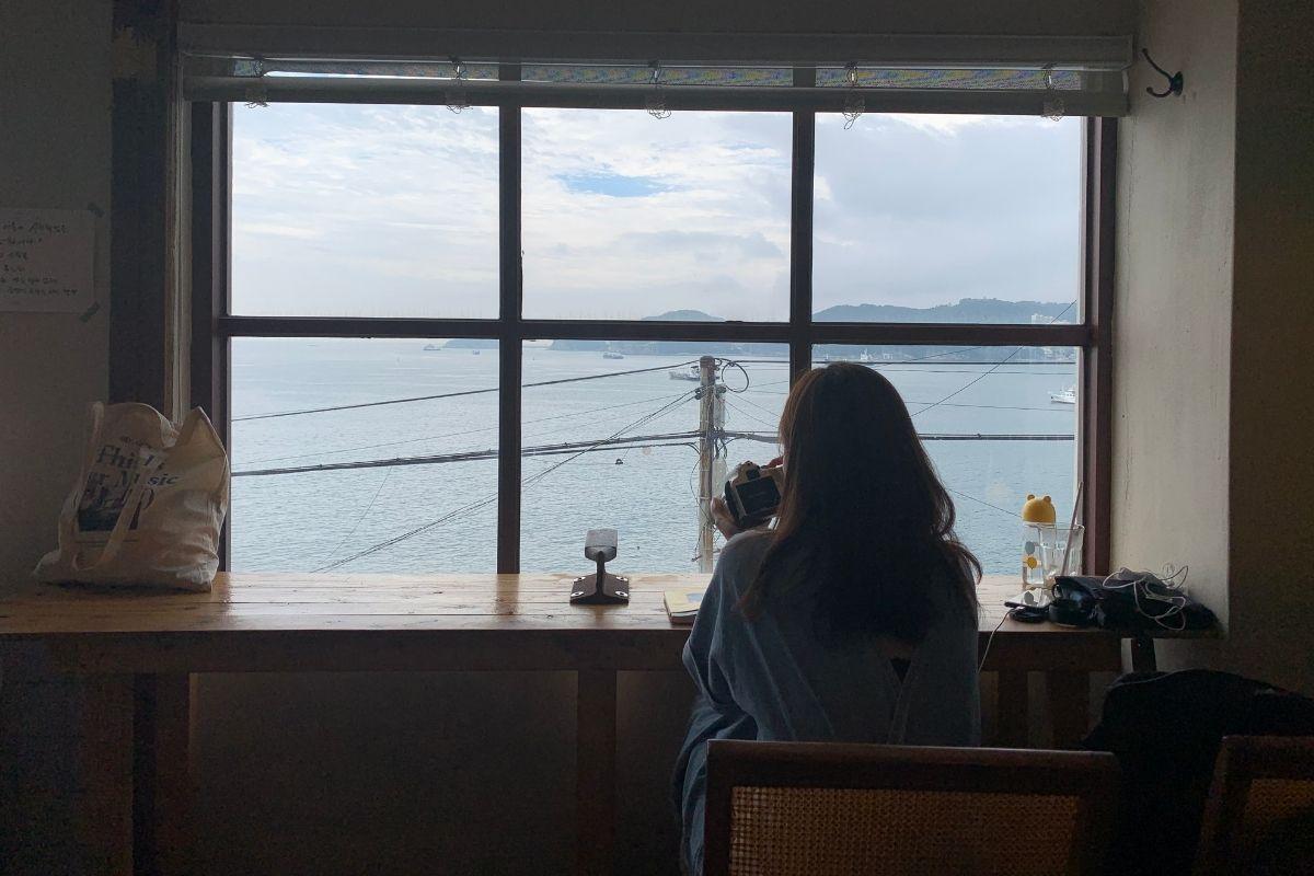 aesthetic ocean view, girl sitting by window, Sonmokseoga cafe, Huinnyeoul Culture Village, Busan, Korea