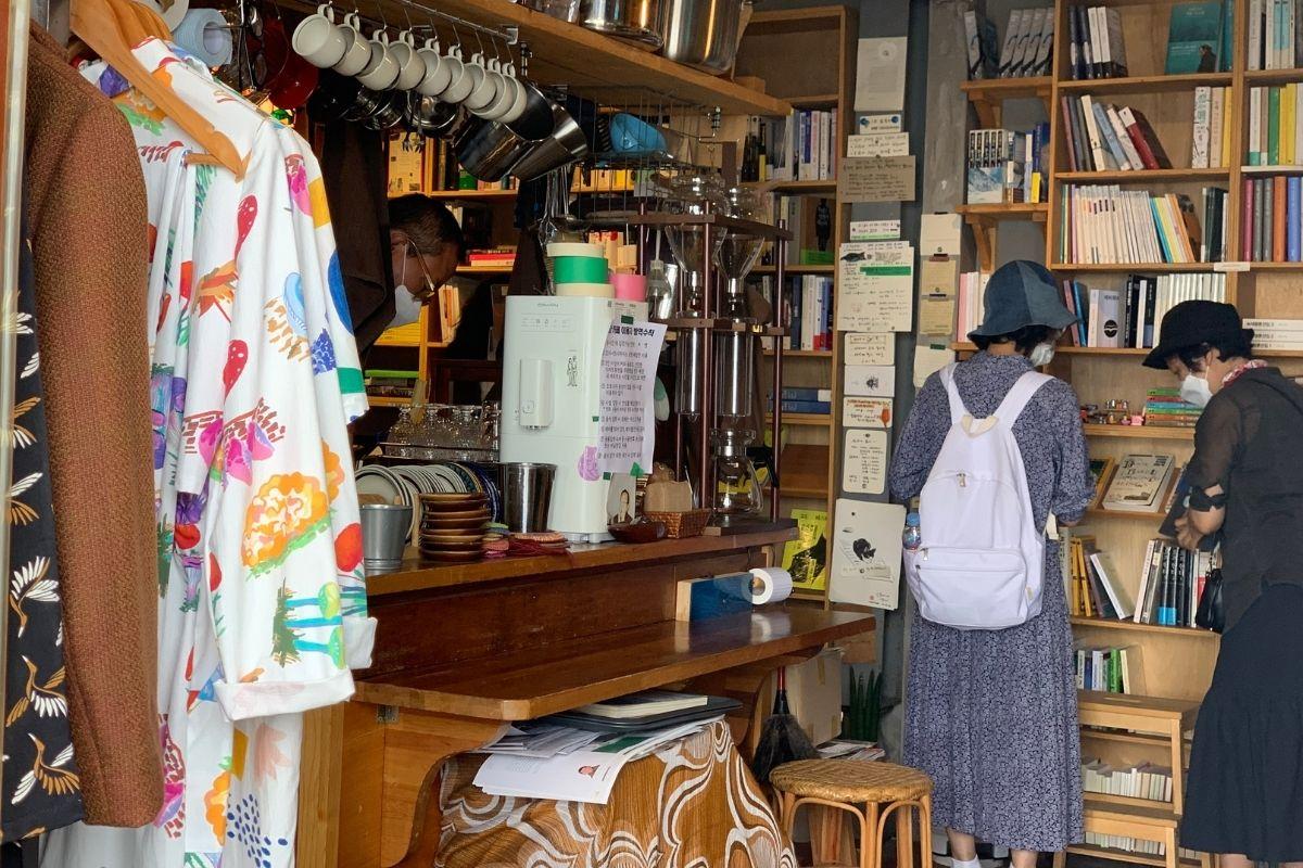 people ordering inside, clothes, books, bookshelves, Sonmokseoga cafe, Huinnyeoul Culture Village, Busan, Korea