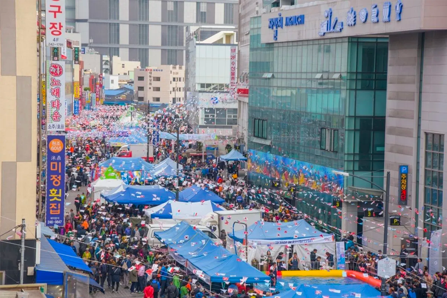釜山札嘎其市场游客享受海鲜的热闹场景。札嘎其市场是韩国最大、最著名的海鲜市场之一，聚集了各种新鲜的海鲜摊位及餐厅。