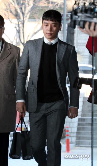 スポーツ京鄕の写真に登場するスーツを着用した男性が建物の外で歩いている様子。