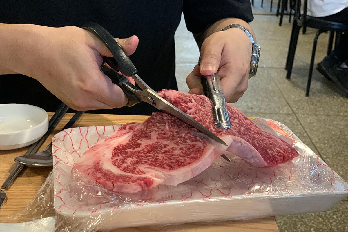 嘗試切割新鮮韓牛肉，準備在餐桌上燒烤享用。