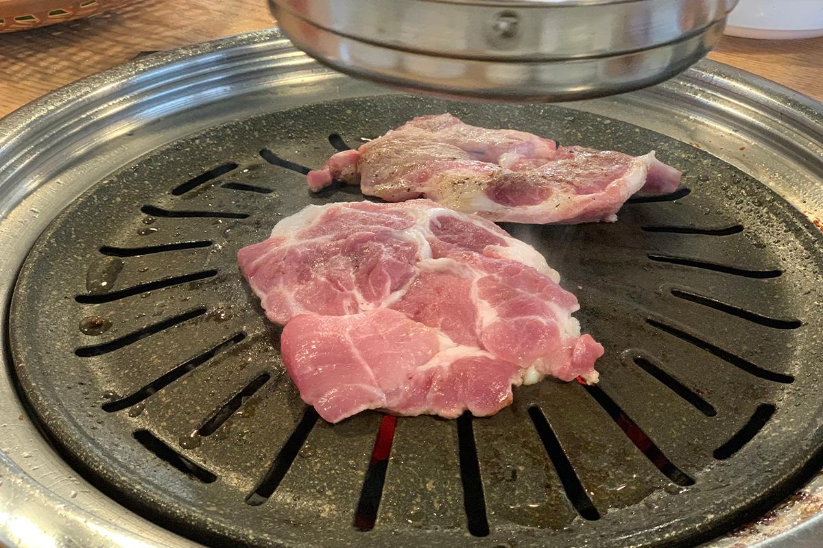 在石板上香煎的豬肉具有濃鬱的色澤和多汁的質地。