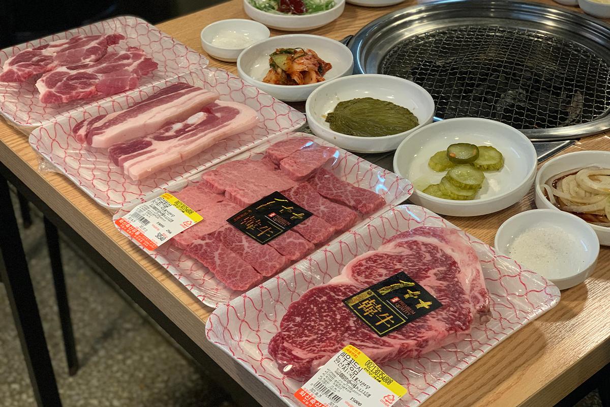 新鮮韓牛與上等的五花肉和其他部位肉品一同擺放在桌上，預備燒烤。