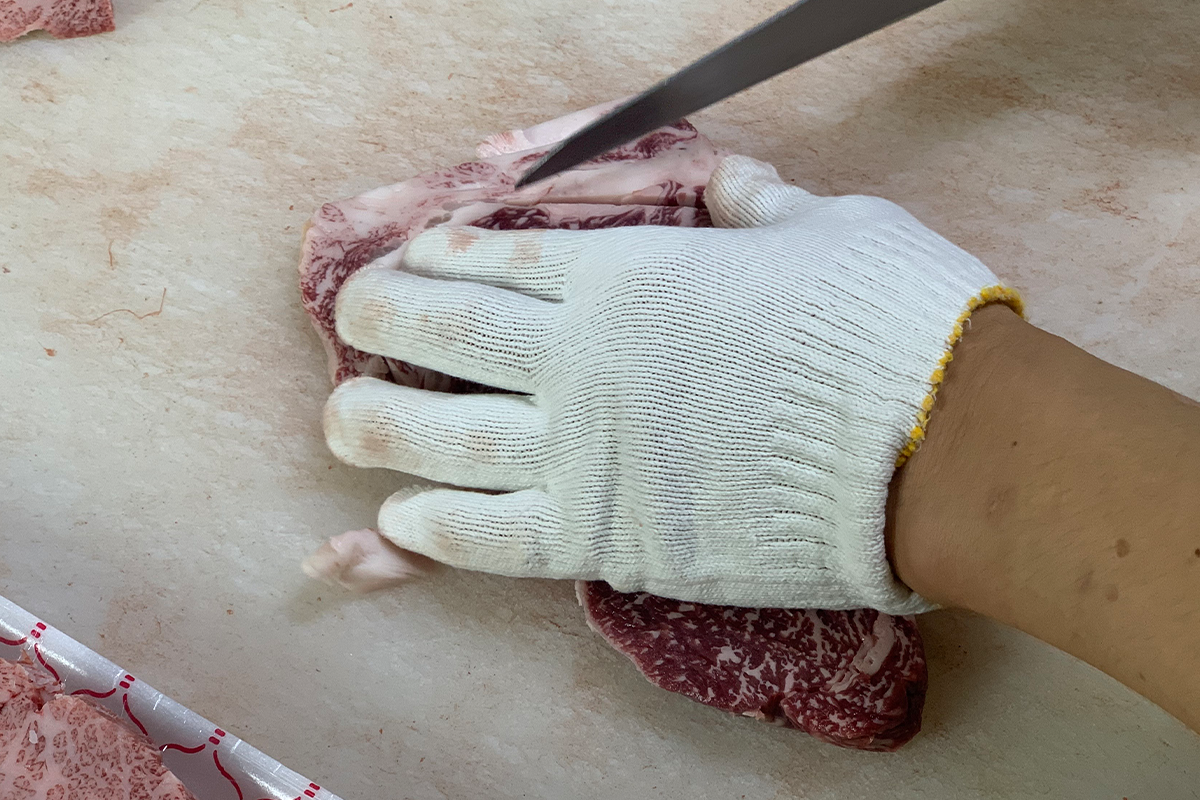 Butcher trimming fat from beef
