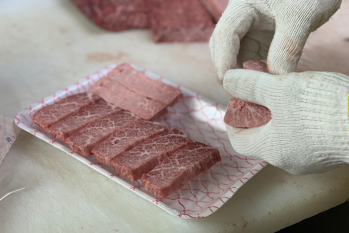 韓牛肉被小心地置於塑料託盤中，準備被包裝。