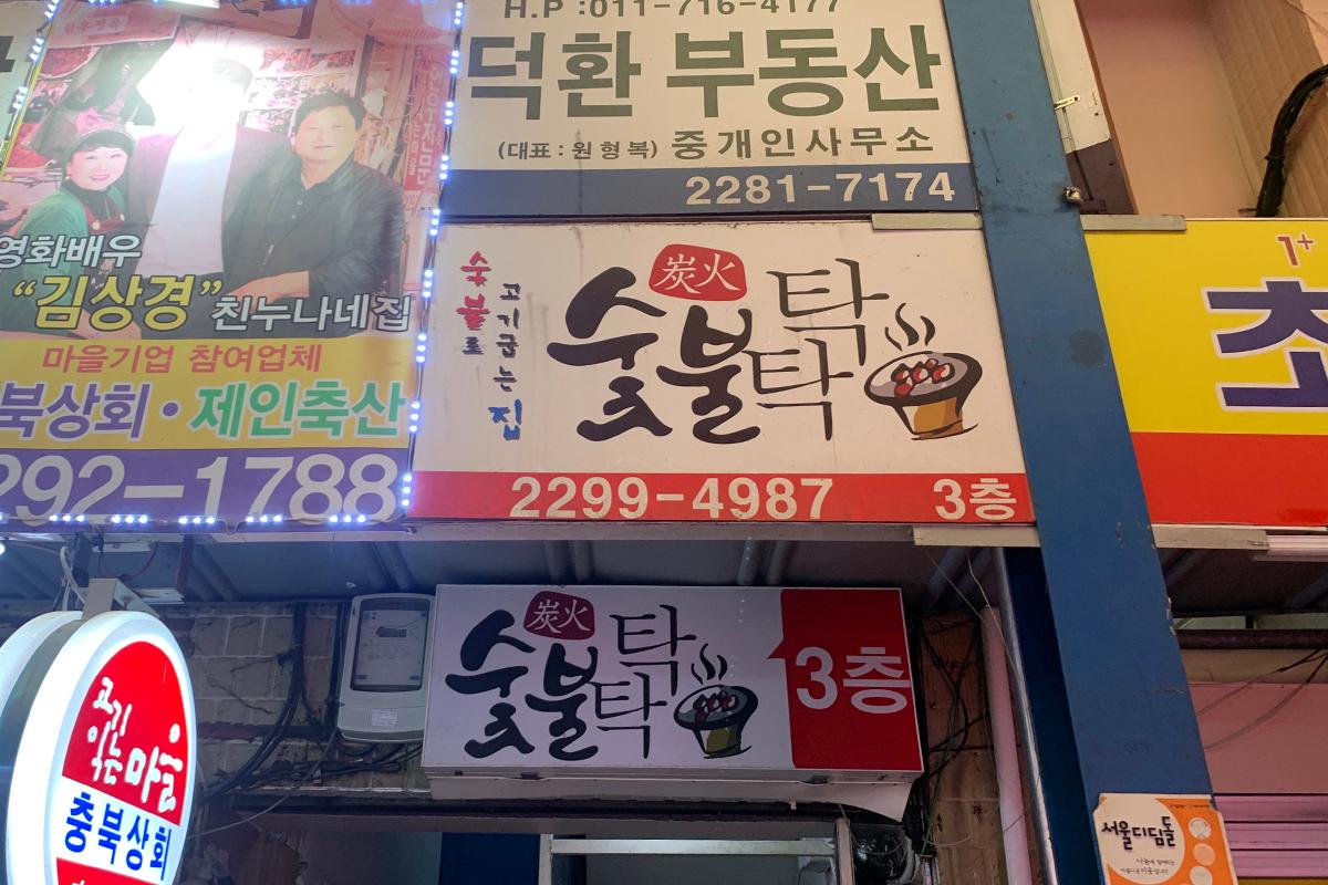 韓國燒烤店外牆上明亮的招牌，主要提供炭火燒烤。
