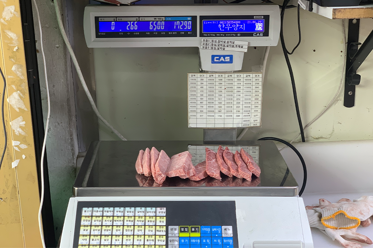 Scale measuring amount of beef to be purchased by customer