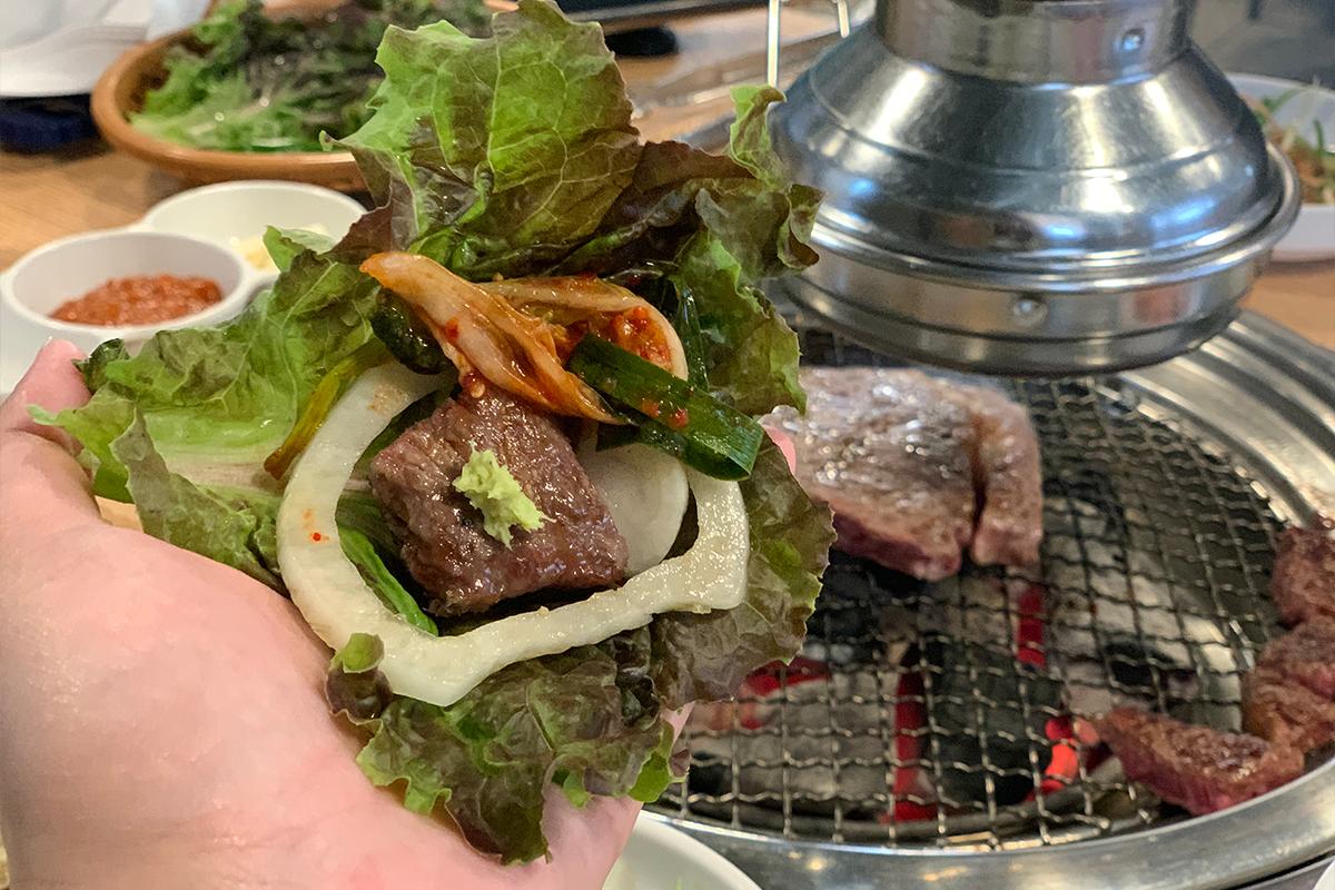 生菜包著剛烤好的韓牛肉，配以洋蔥和泡菜。