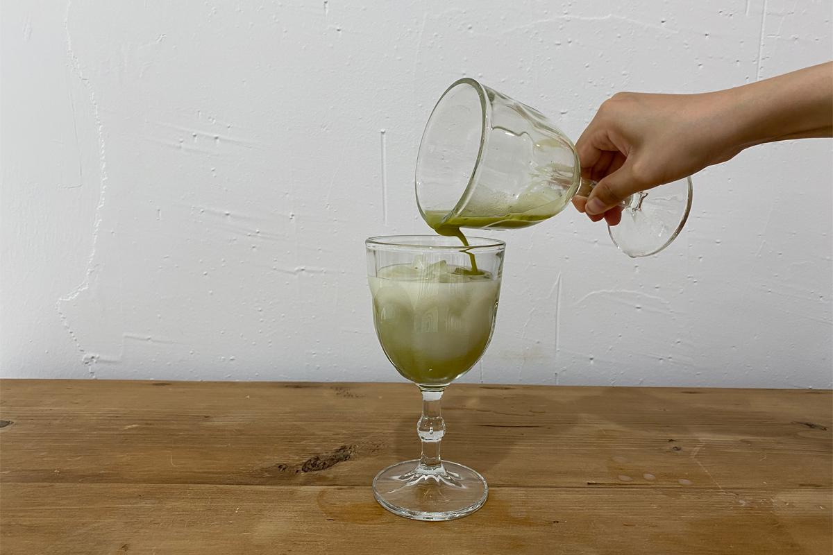 Adding green tea to glass with makgeolli